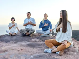 Personas sentadas practicando meditación.